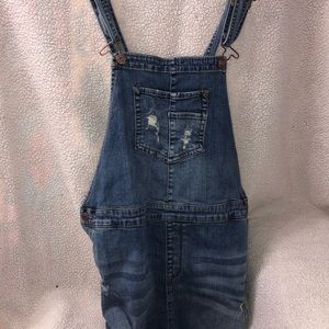 A denim overalls dress with distressing